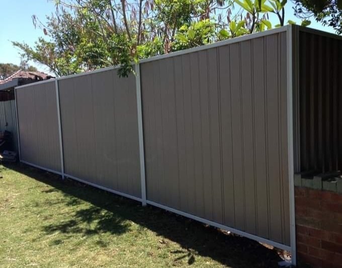 A tall Colorbond privacy fence on a corner block