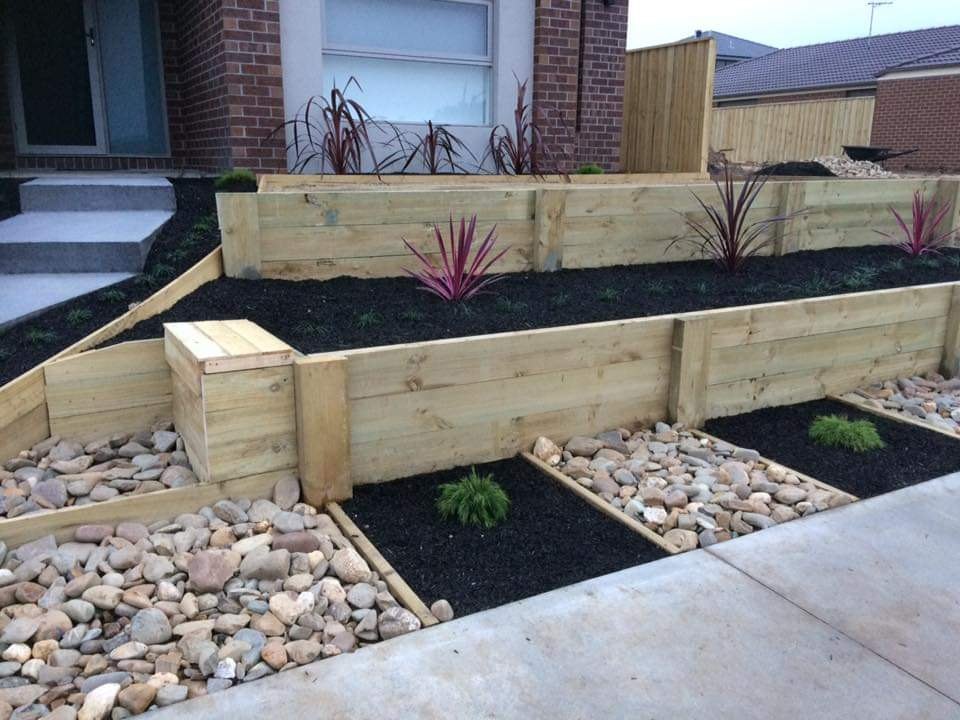 A terraced timber retaining wall with new garden beds